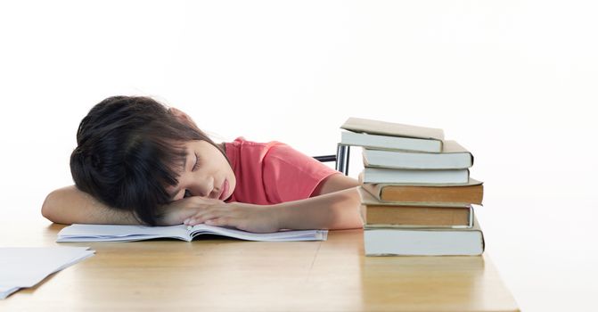 Tired schoolgirl sleeps at the desk, close up