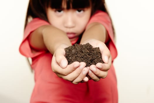 Girl holding soil on her hand
