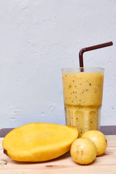 Smoothie juice, mix Mango with passion fruit on wood background