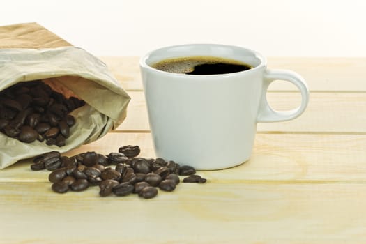 white coffee cup on wood background, with coffee beans