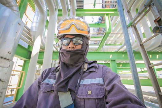 Man with safety personal protection equipment in industrial plant background 