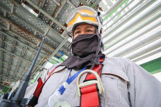 Man with safety personal protection equipment in industrial plant background 