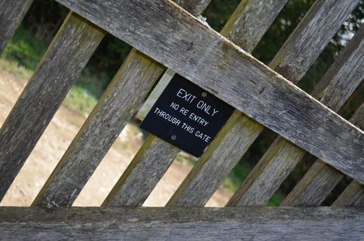 A sign on a gate informing  that it is used only as a means of exit.