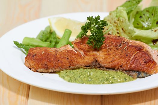 Grilled salmon steak with Salsa Verda sauce , lemon and vegetables