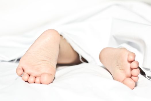 Baby sleeping in bed focus on feet