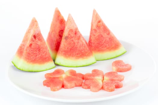 Watermelon slice and heart shape on white plate