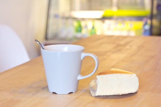 A cup of coffee and Piece of cheesecake in coffee shop