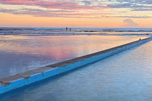 Looking across two of the three ocean pools and rock shelf at North Narrabeen at sunrise.  Sydney's Northern Beaches, NSW Australia.  Focus to foreground only.