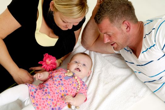 Mother and father are looking at their sweet smiling 4 month old baby.