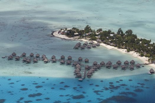 aerial view of over water bungalows and the island of bora bora