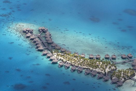 aerial view of over water bungalows and the island of bora bora