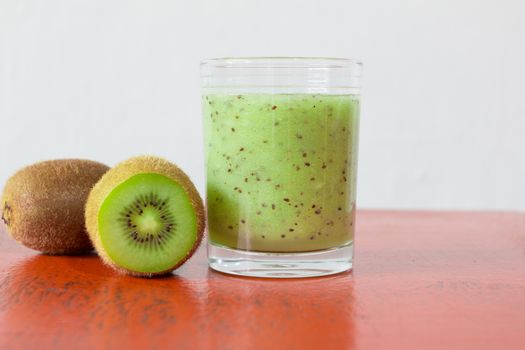 Smoothie kiwi on red wood background