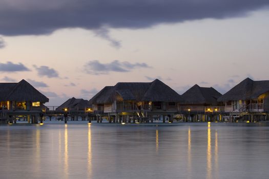 image of  over water bungalows with light at dusk in bora bora