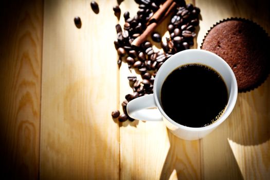 Cup coffee with coffee beans on wood background