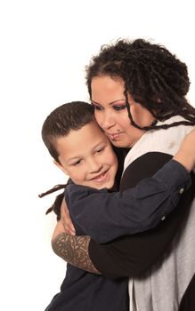 Funky, alternative mother with long dreadlocks, tattoos, and piercings hugs her son happily on a white background