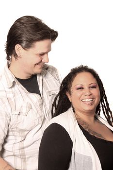 Ethnic couple on a white background with man lovingly looking at his laughing wife
