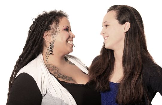Tattooed mother with dreadlocks and piercings with her daughter looking at eachother happily on a white background
