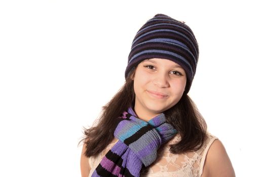 Young pretty pre teen brunette girl smiling wearing a wool hat and scarf on a white background 