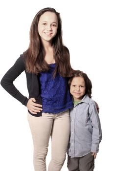 Older sister or babysitter standing beside little brother on a white background