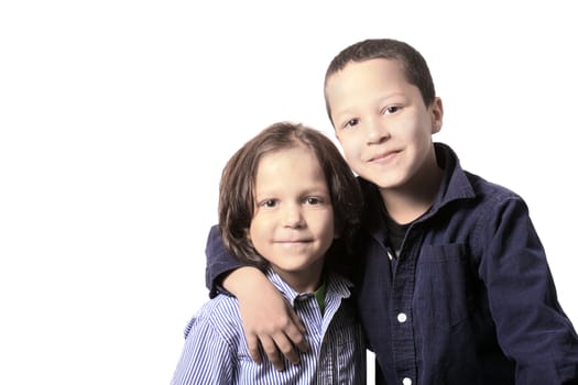 High key portrait of two young little brothers or friends arm in arm on a white background
