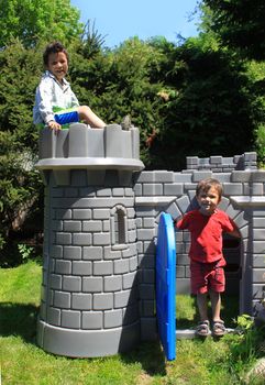 Two boys playing outside in plastic castle