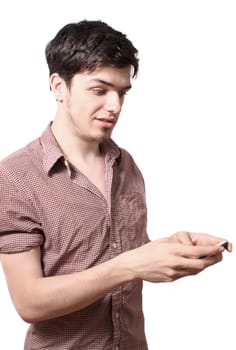 Eighteen year old young man holding his cellphone on a white background with surprised or astonished look on his face