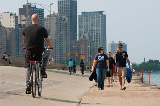 CHICAGO, IL - MAY 26, 2012:  Pedestrians and people on bicycles enjoy being outdoors along the Lake Michigan shoreline, just off Chicago's famous Lakeshore Drive.  The warm temperatures and Memorial Day holiday weekend brought thousands of people outdoors.