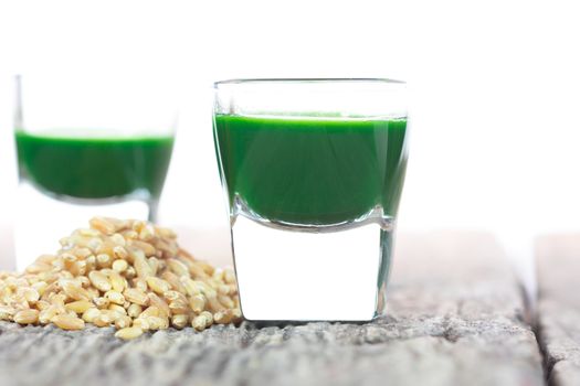 Wheat grass juice on wood with wheat
