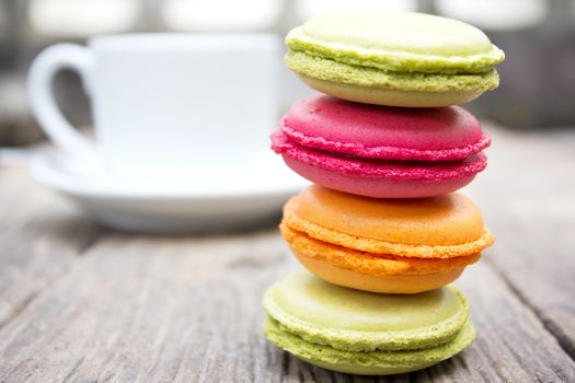 Macaroons on a wooden table with cup of coffee