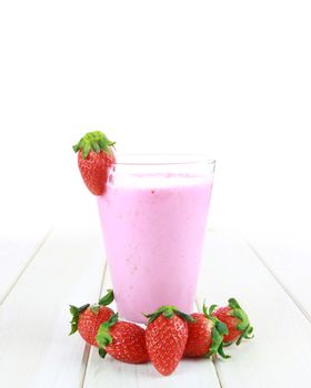 glass of strawberry smoothie on a wooden background
