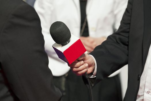 A journalist is making a interview with a microphone