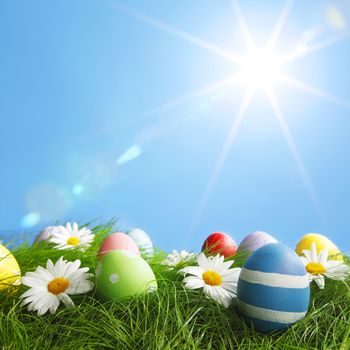 Easter Greeting Card with decorated Easter eggs in the grass and flowers