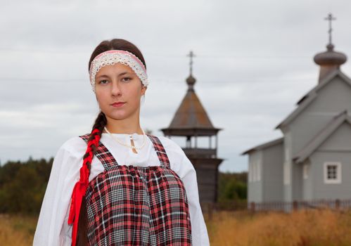 Pomorian girl in national dress on a background of the church 