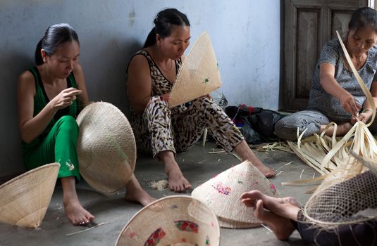 QUY NHON, VIET NAM- JUNE 16: People working indoor, they making conical hat, Quy Nhon, June 16,2012