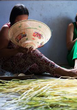 QUY NHON, VIET NAM- JUNE 16: People working indoor, they making conical hat, Quy Nhon, June 16,2012