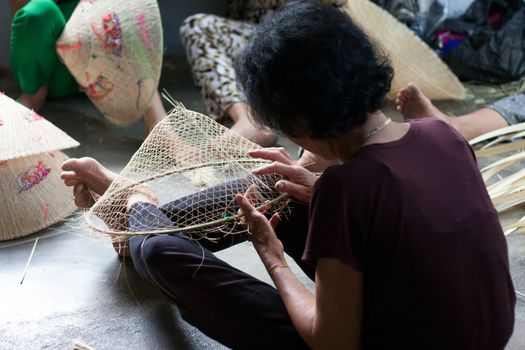 QUY NHON, VIET NAM- JUNE 16: People working indoor, they making conical hat, Quy Nhon, June 16,2012