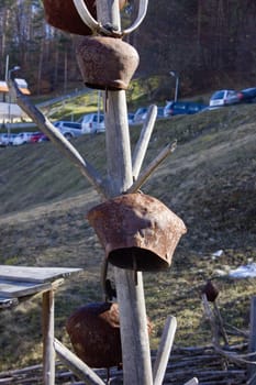 Cow bells hung from a wooden pole. Picture taken in a old village yard.