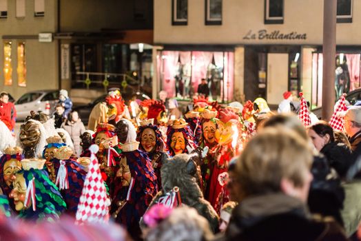 NEUHAUSEN, GERMANY ��� MARCH 4, 2014: Masked people are celebrating the end of carnival (fasnet) season by burning a puppet that is wearing a traditional costume (called the ���H��s���) symbolizing carnival on March 4, 2014 in Neuhausen (near Stuttgart), Germany. Carnival has a very long tradition in Neuhausen with influences of the swabian alemanisch culture that can be seen by the wooden masks people are wearing as part of their costumes.