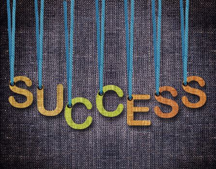 Success Letters hanging strings with blue sackcloth background.