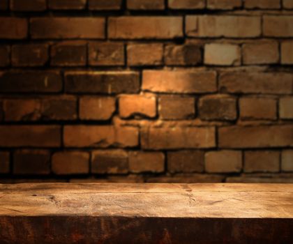 Empty wooden table and brick wall in background
