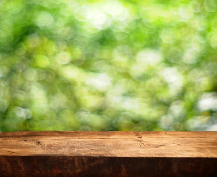 Empty wooden table and green summer background