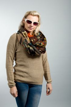 close up studio portrait of beautiful woman with sweater, scarf and sun glasses