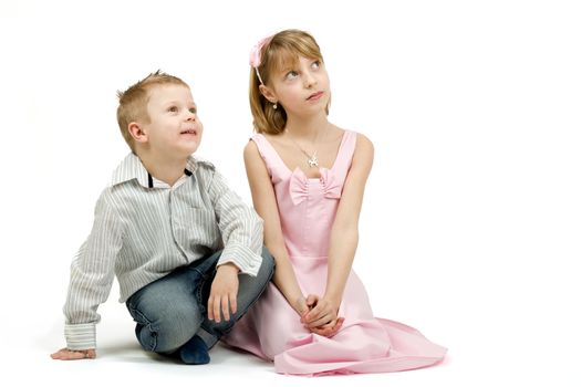 Studio portrait of siblings beautiful boy and girl on white background looking up