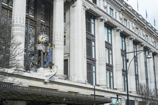 LONDON, UK - MARCH 14: Facade of famous department store Selfridges, with statue of angel holding clock. March 01, 2014 in London.