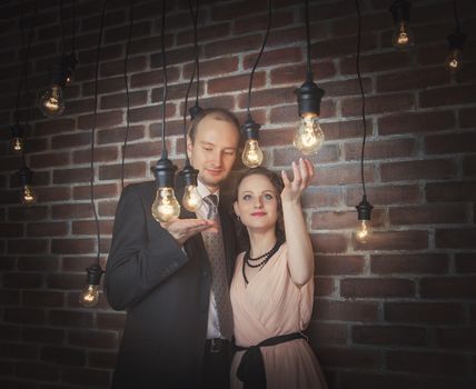 loving couple in the background of walls from a brick and light bulbs