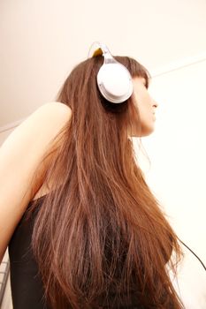 A young woman to Music with headphones.