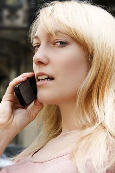 A young adult woman talking on the phone.