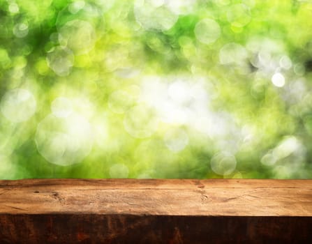 wooden table with space for your photo montage and green color of background