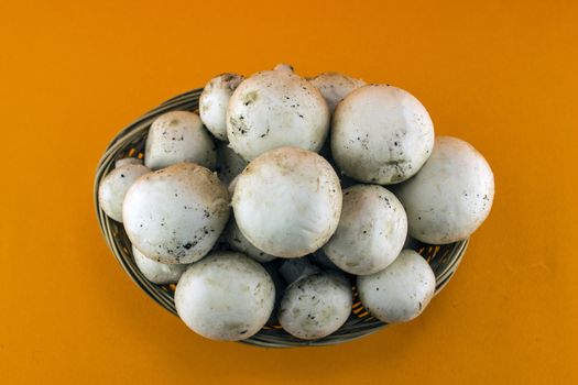 button mushrooms in straw basket, champignons.