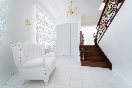 white armchair in the hallway with a staircase